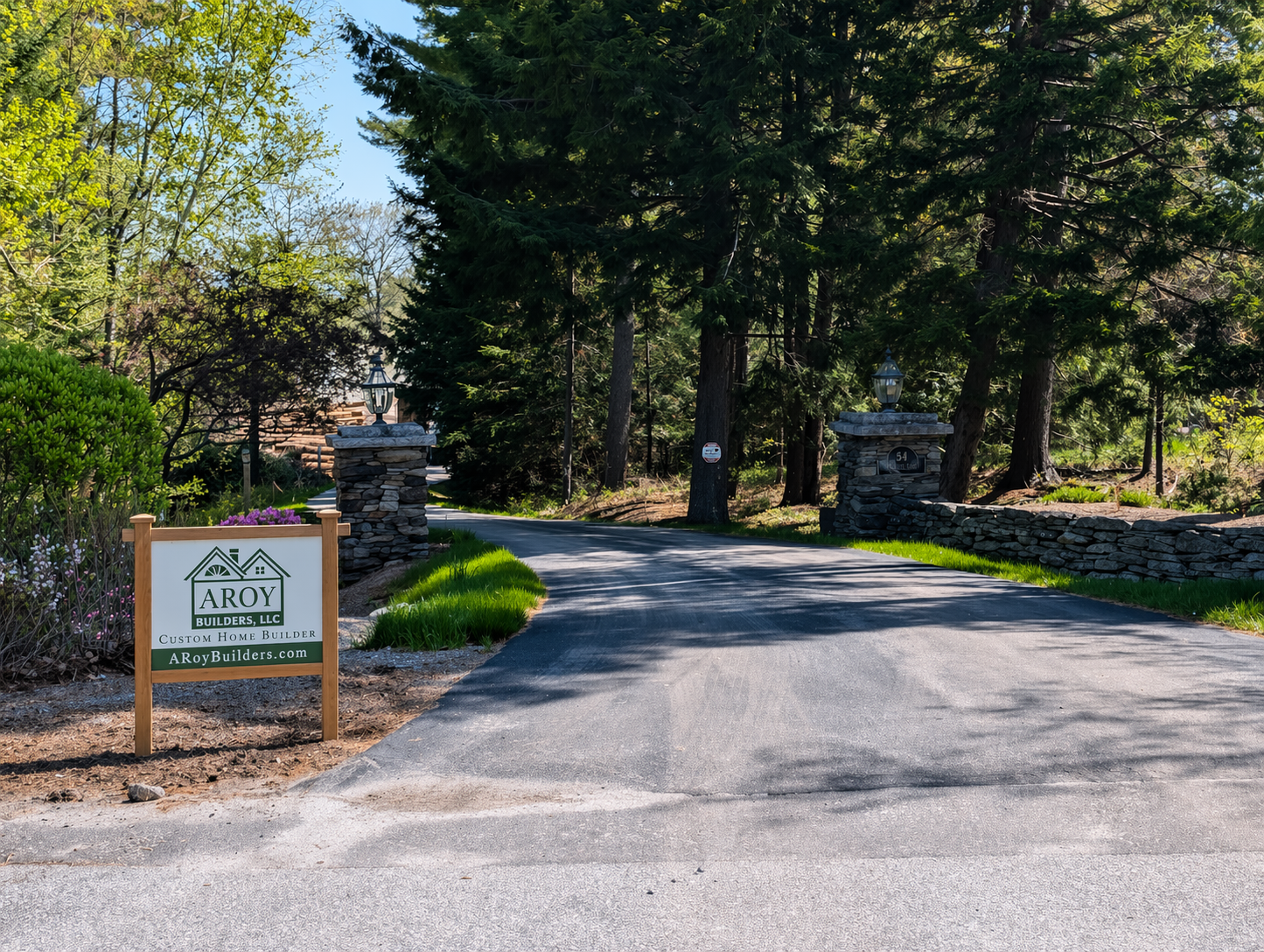 ARoy Builders sign at end of new driveway with stone walls